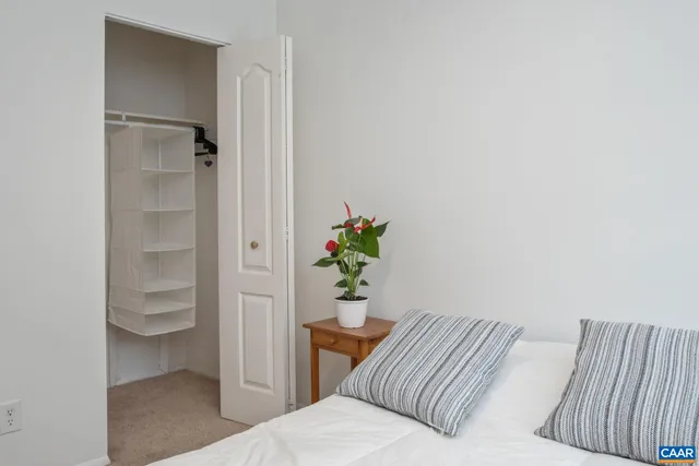 a bedroom with a bed and a potted plant