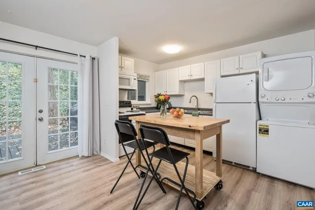 a kitchen with a table chairs refrigerator and cabinets