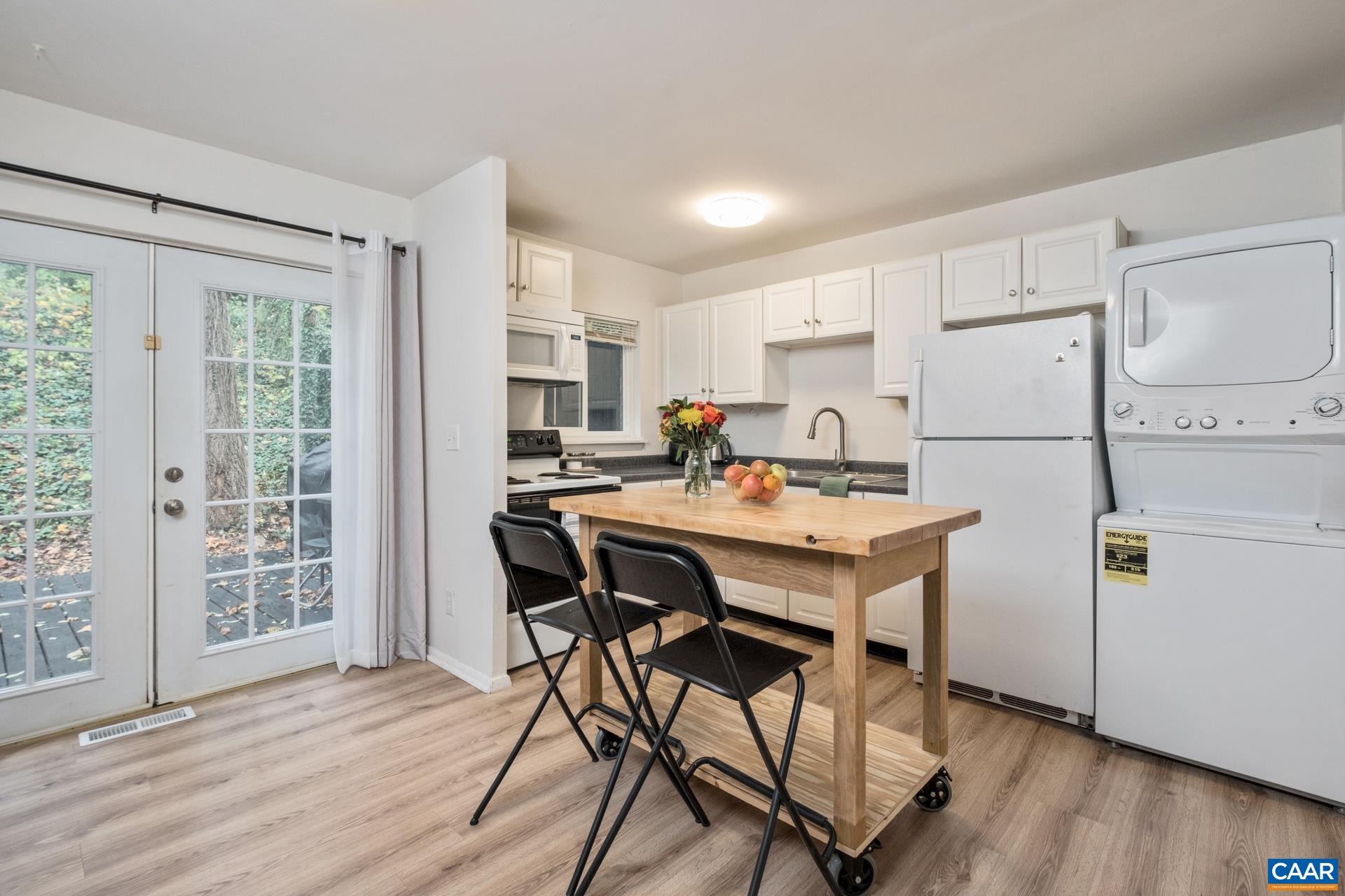 407 Valley Rd Extension, Unit A Charlottesville, VA 22903 - Photo 6 of 24 a kitchen with a table chairs refrigerator and cabinets