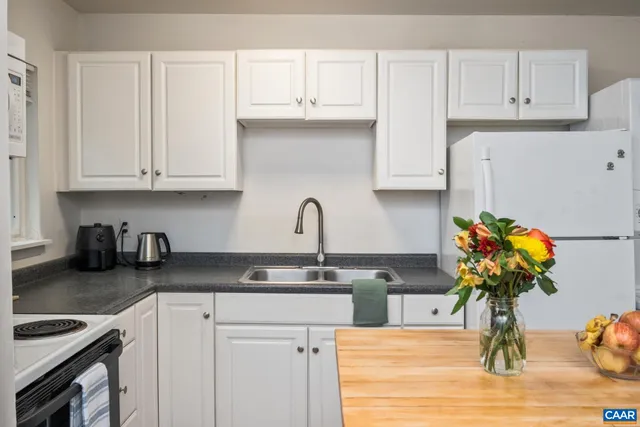 a kitchen with stainless steel appliances granite countertop a sink a stove top oven a counter space and cabinets