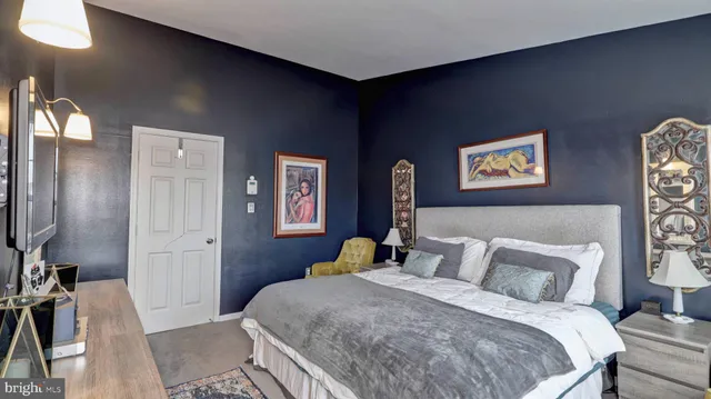 a bedroom with a bed and a painting on the wall
