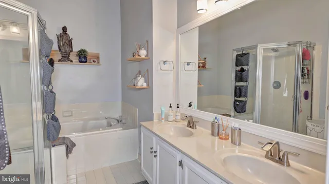 a bathroom with a granite countertop sink mirror and a bathtub