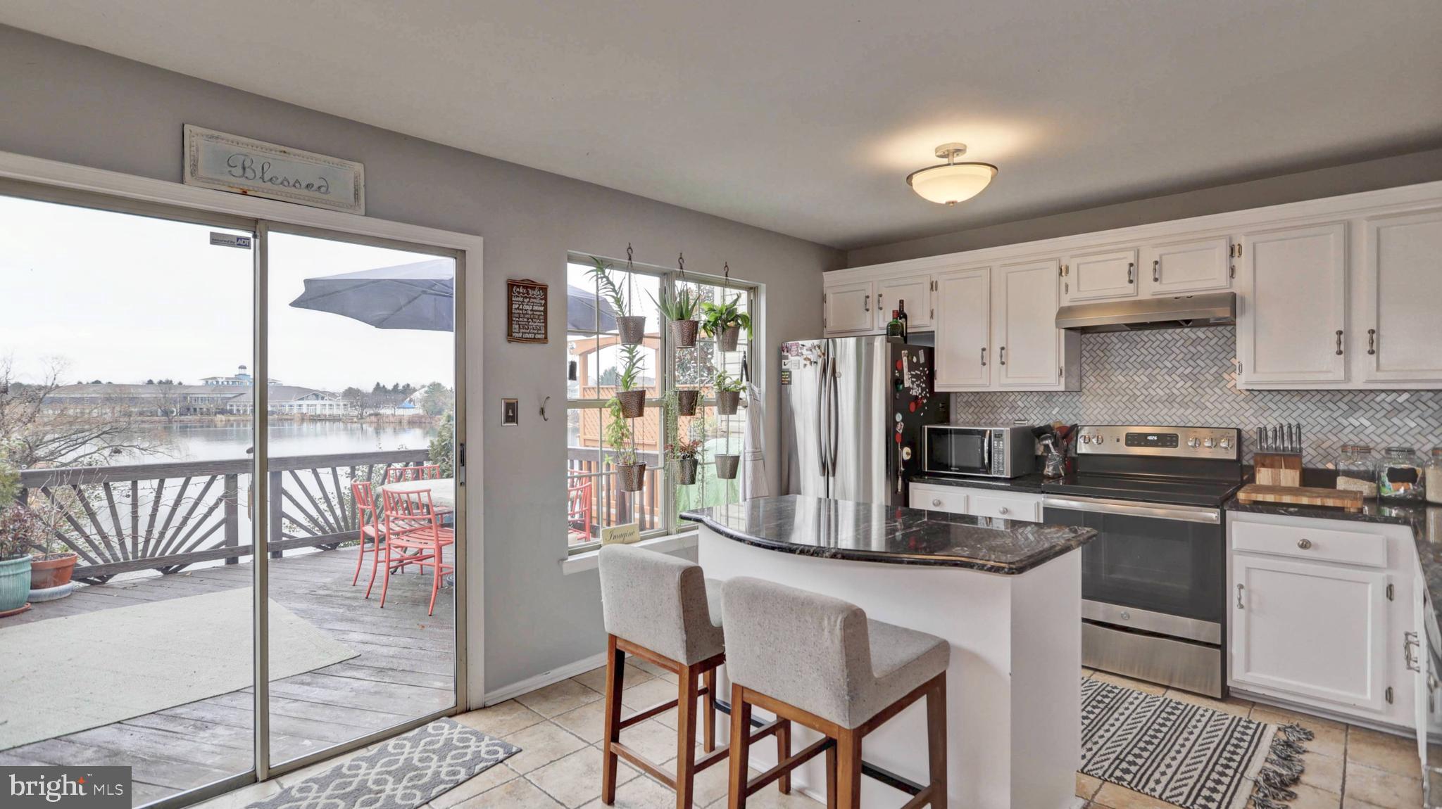 44072 Florence Terrace Ashburn, VA 20147 - Photo 2 of 31 a kitchen with a table chairs refrigerator and cabinets