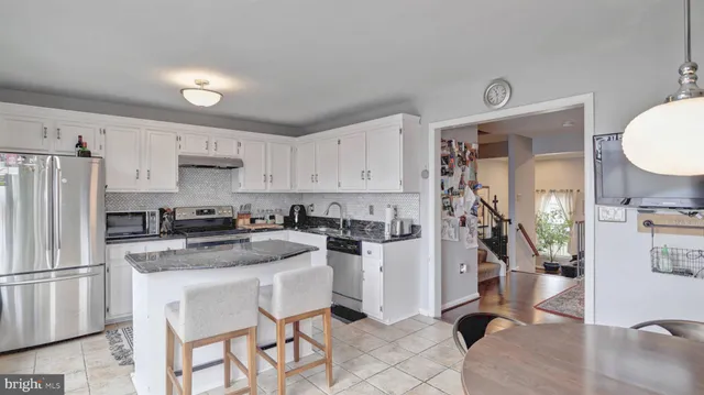 a kitchen with a refrigerator a stove a sink dishwasher and white cabinets with wooden floor