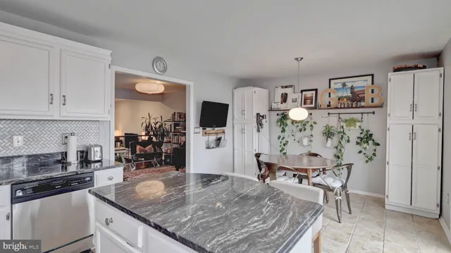 a kitchen with stainless steel appliances granite countertop a stove top oven a dining table and chairs with wooden floor