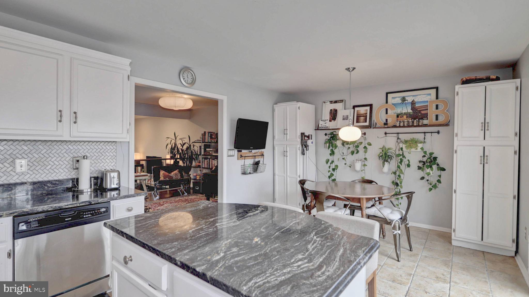 44072 Florence Terrace Ashburn, VA 20147 - Photo 5 of 31 a kitchen with stainless steel appliances granite countertop a stove top oven a dining table and chairs with wooden floor