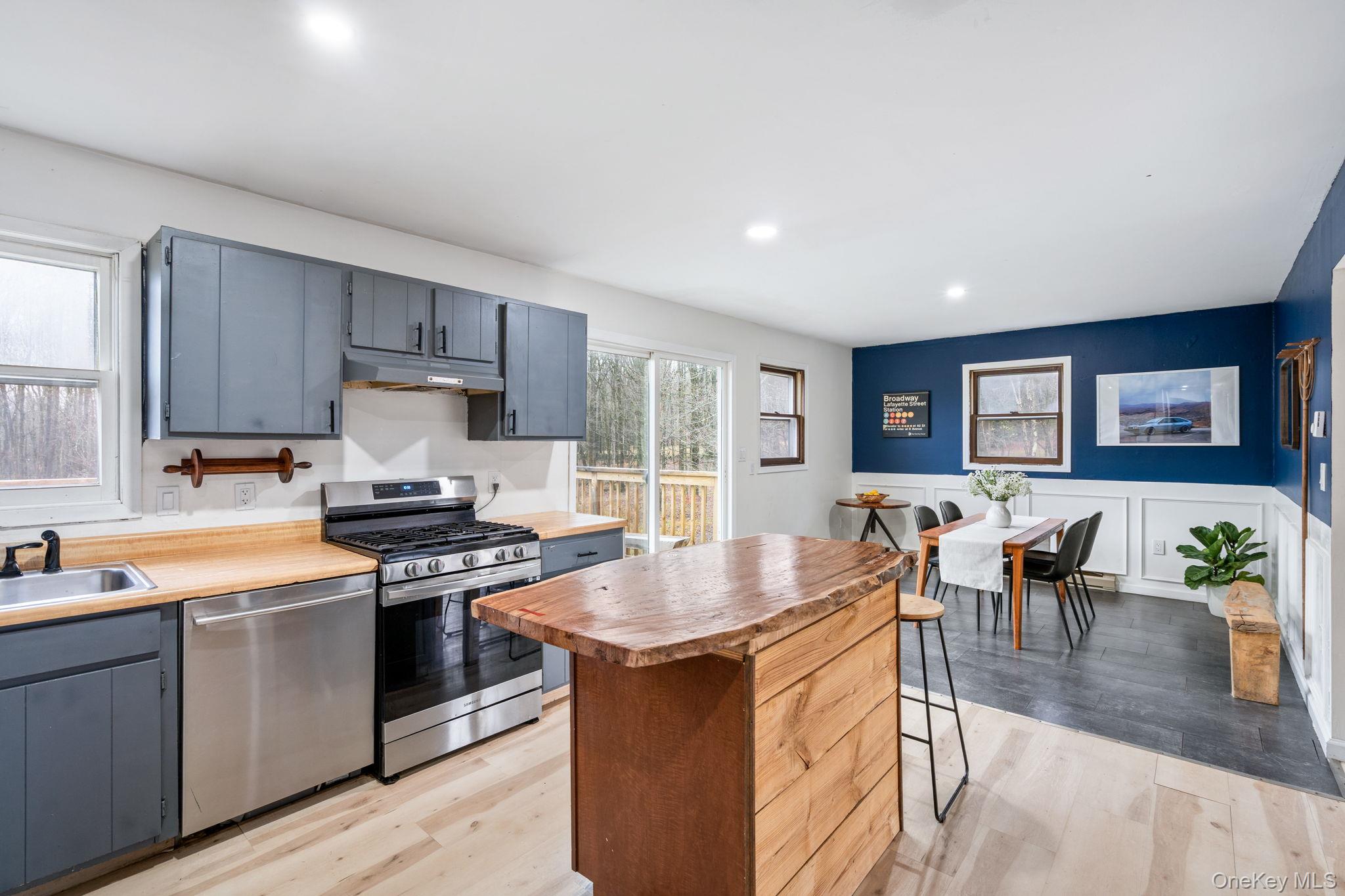 178 Bowers Road Loch Sheldrake, NY 12759 - Photo 12 of 47 a kitchen with stainless steel appliances granite countertop a stove top oven a sink dishwasher a dining table and chairs with wooden floor
