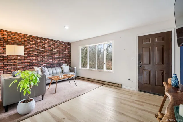 a living room with furniture potted plant and wooden floor