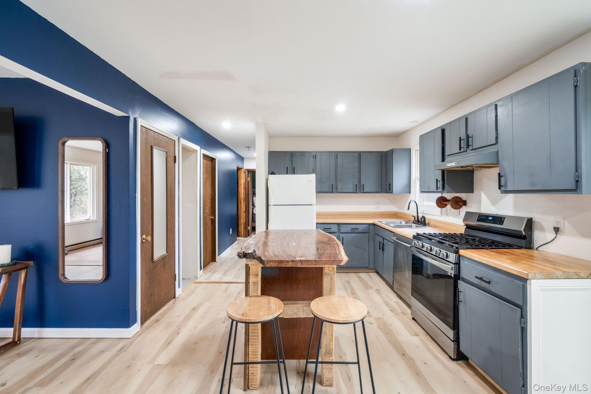 178 Bowers Road Loch Sheldrake, NY 12759 - Photo 10 of 47 a kitchen with a table chairs refrigerator and cabinets