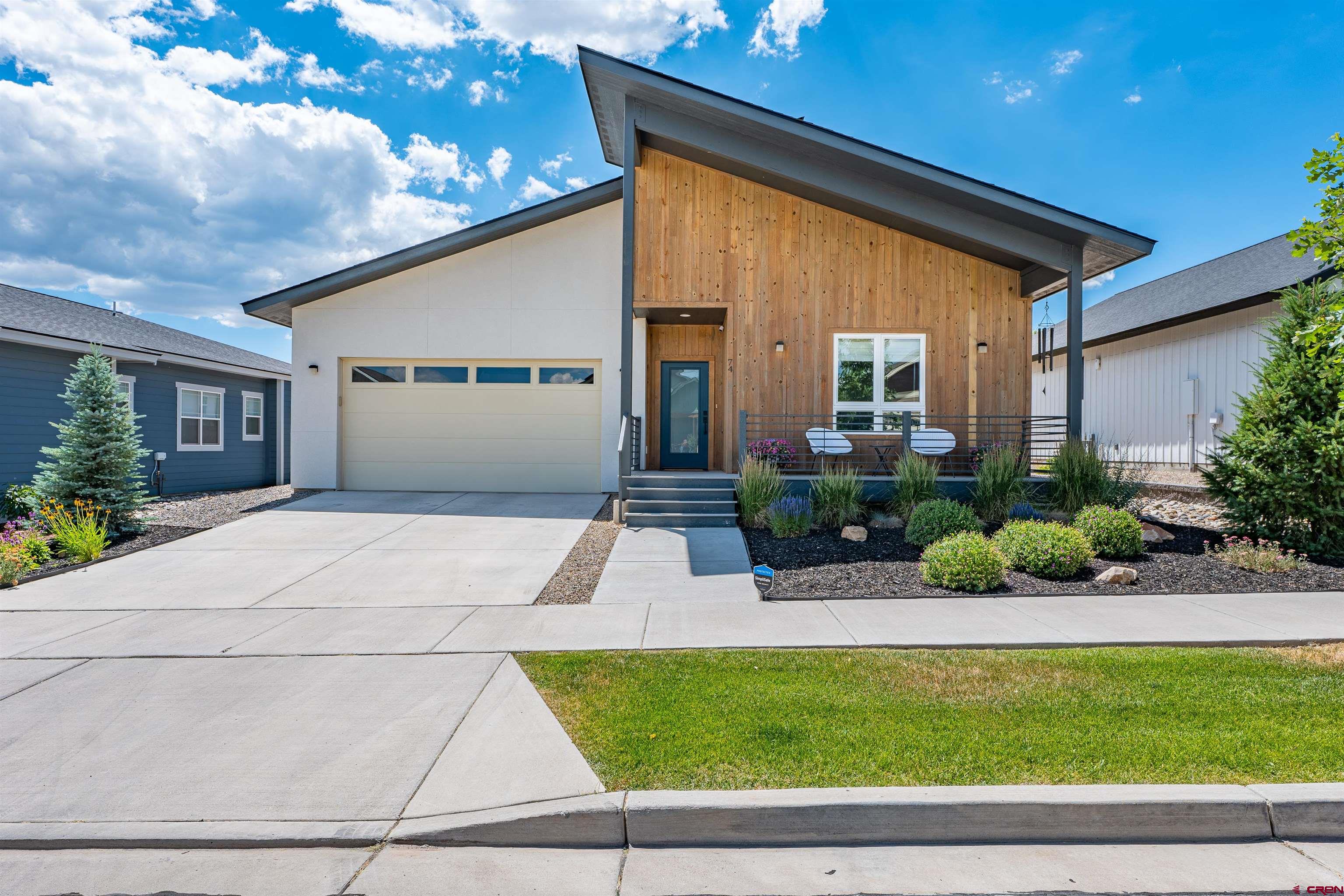 a front view of a house with a yard and potted plants