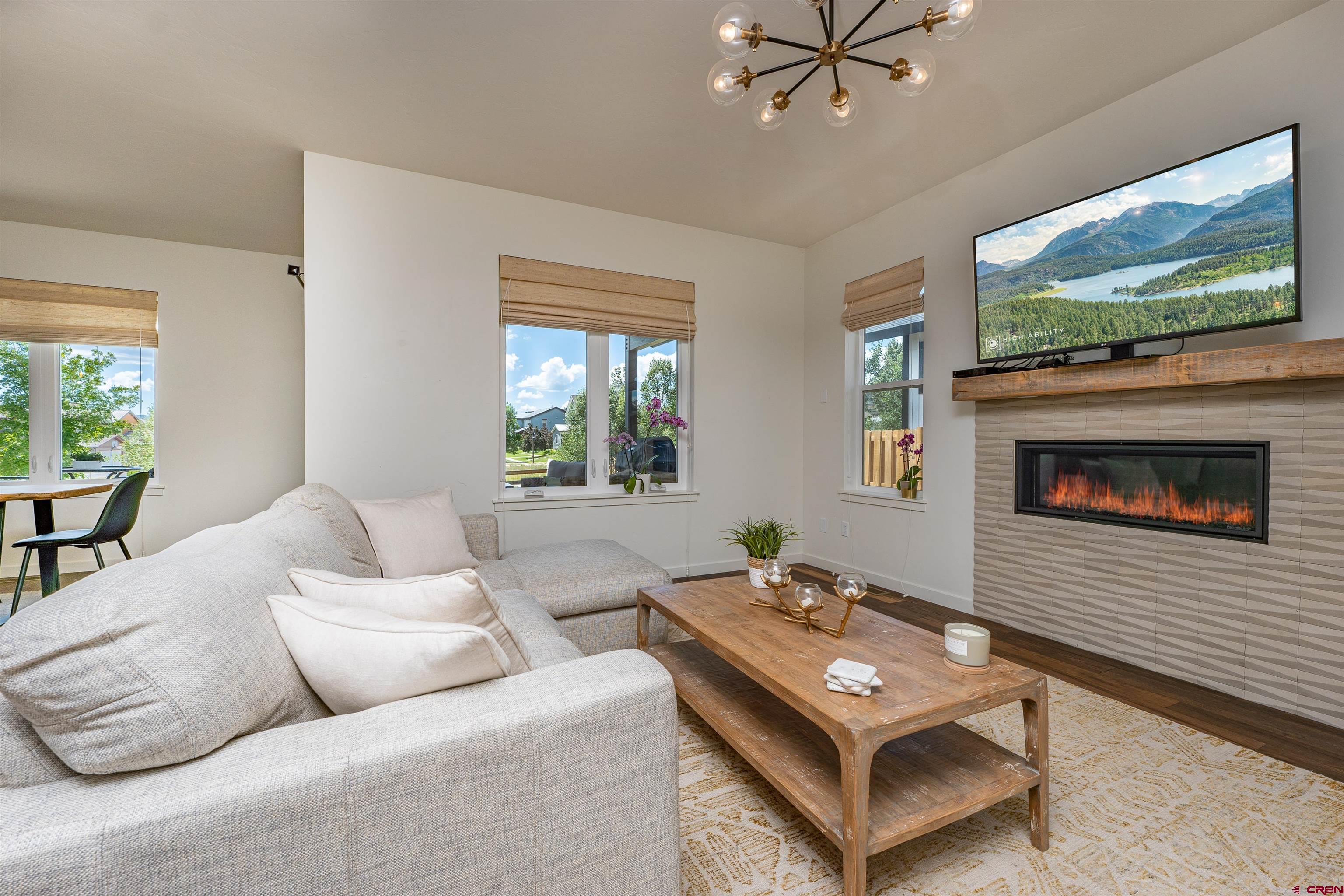 74 Prospector Avenue Durango, CO 81301 - Photo 3 of 30 a living room with furniture a flat screen tv and a fireplace