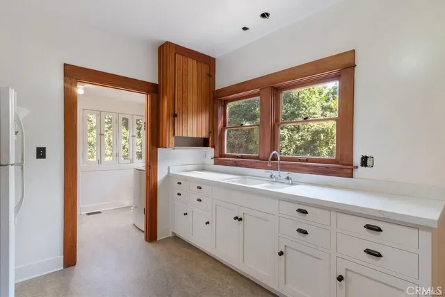 a kitchen with granite countertop white cabinets and white appliances