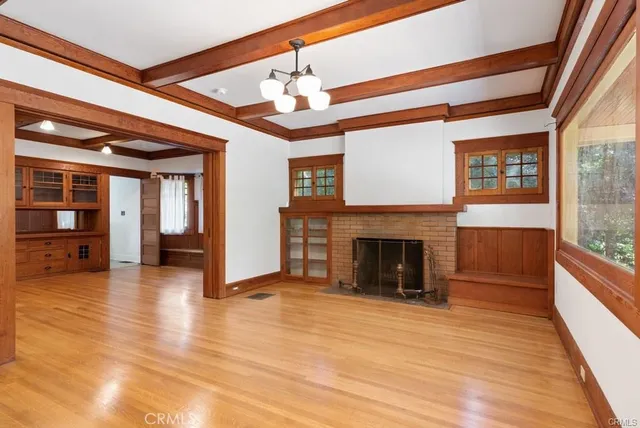 a view of a livingroom with wooden floor and a fireplace