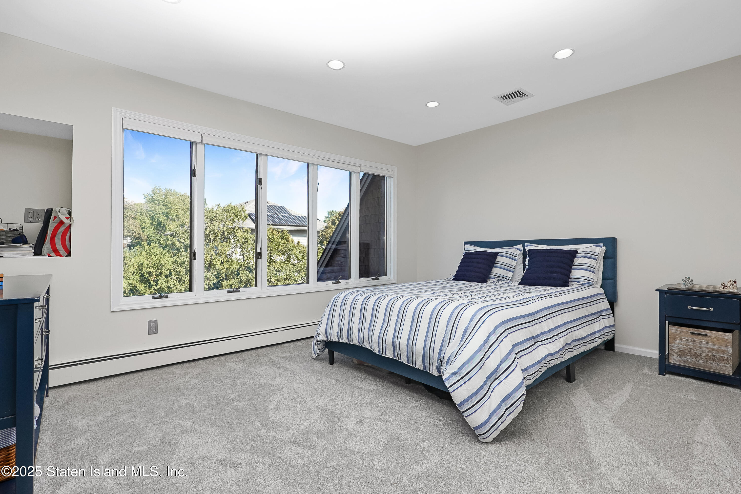 Undisclosed Address Staten Island, NY 10307 - Photo 38 of 72 a spacious bedroom with a bed and a large window