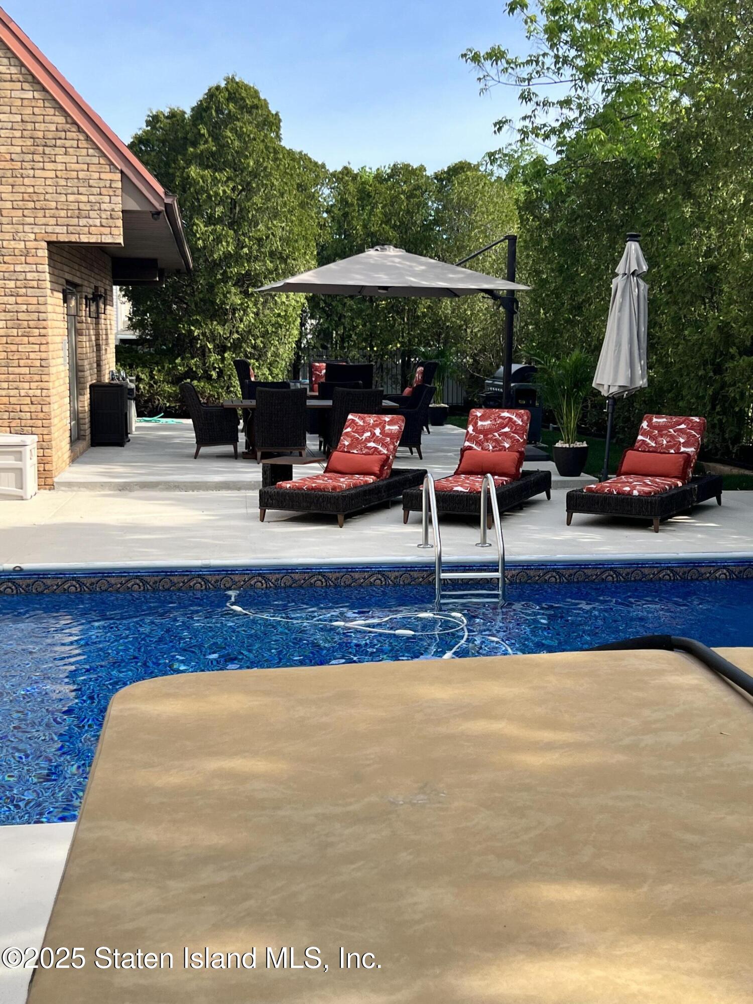 Undisclosed Address Staten Island, NY 10307 - Photo 60 of 72 a view of a patio with table and chairs under an umbrella