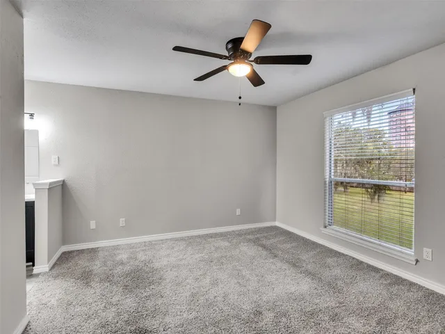 a view of a livingroom with a ceiling fan and window