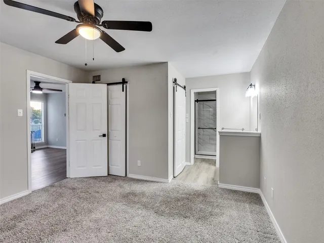 a view of empty room with wooden floor and ceiling fan