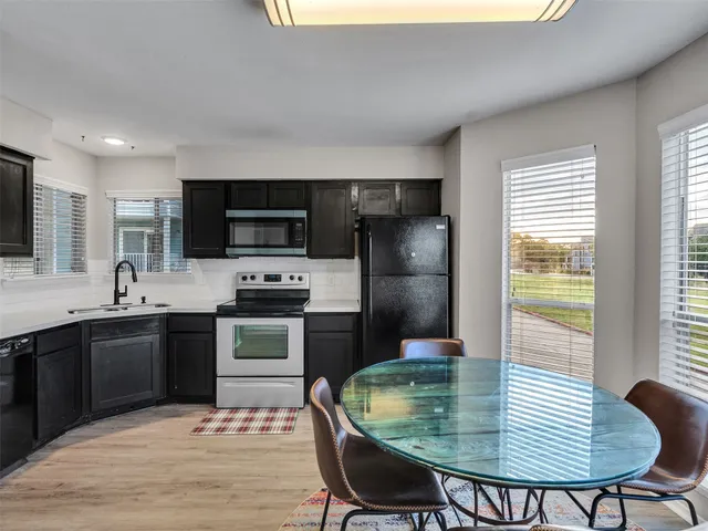 a kitchen with a table chairs sink and refrigerator