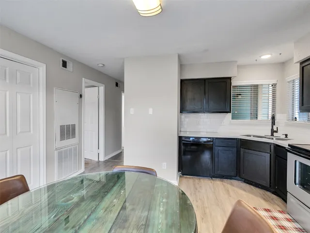 a kitchen with stainless steel appliances granite countertop a sink and a stove top oven with wooden floor