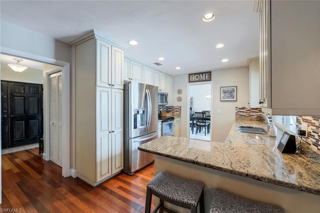 289 Burning Tree Drive Naples, FL 34105 - Photo 12 of 36 a kitchen with stainless steel appliances granite countertop a refrigerator and a sink