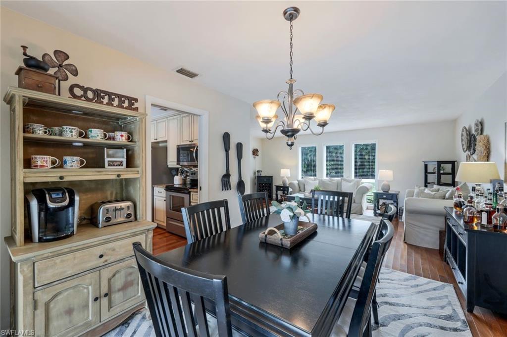 289 Burning Tree Drive Naples, FL 34105 - Photo 14 of 36 a view of a dining room and livingroom with furniture wooden floor a chandelier