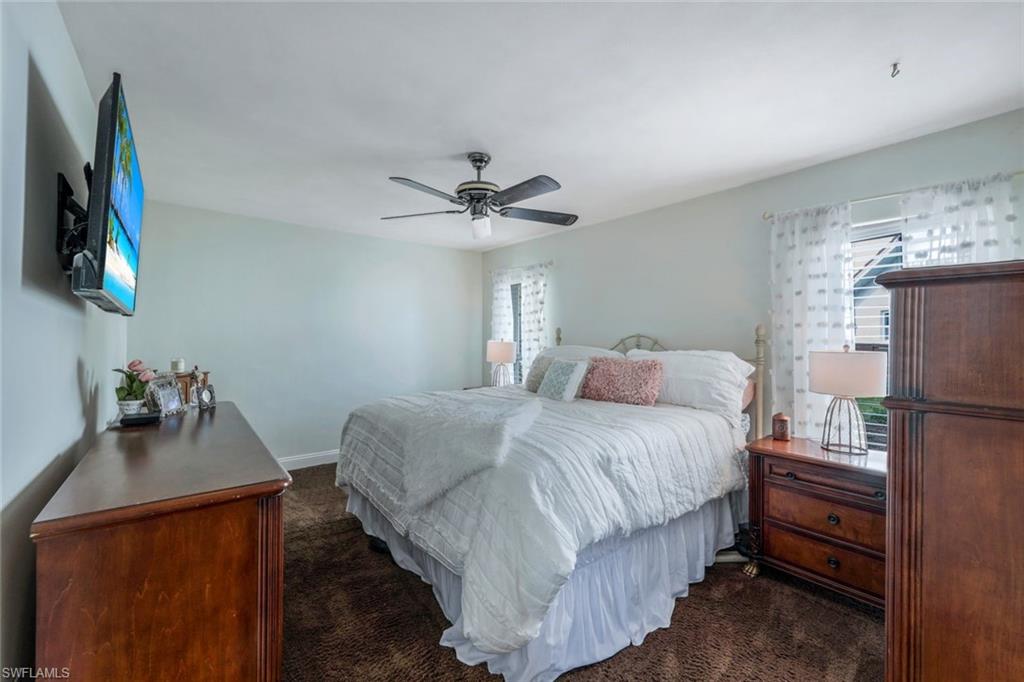 289 Burning Tree Drive Naples, FL 34105 - Photo 15 of 36 a bedroom with a bed and a flat screen tv