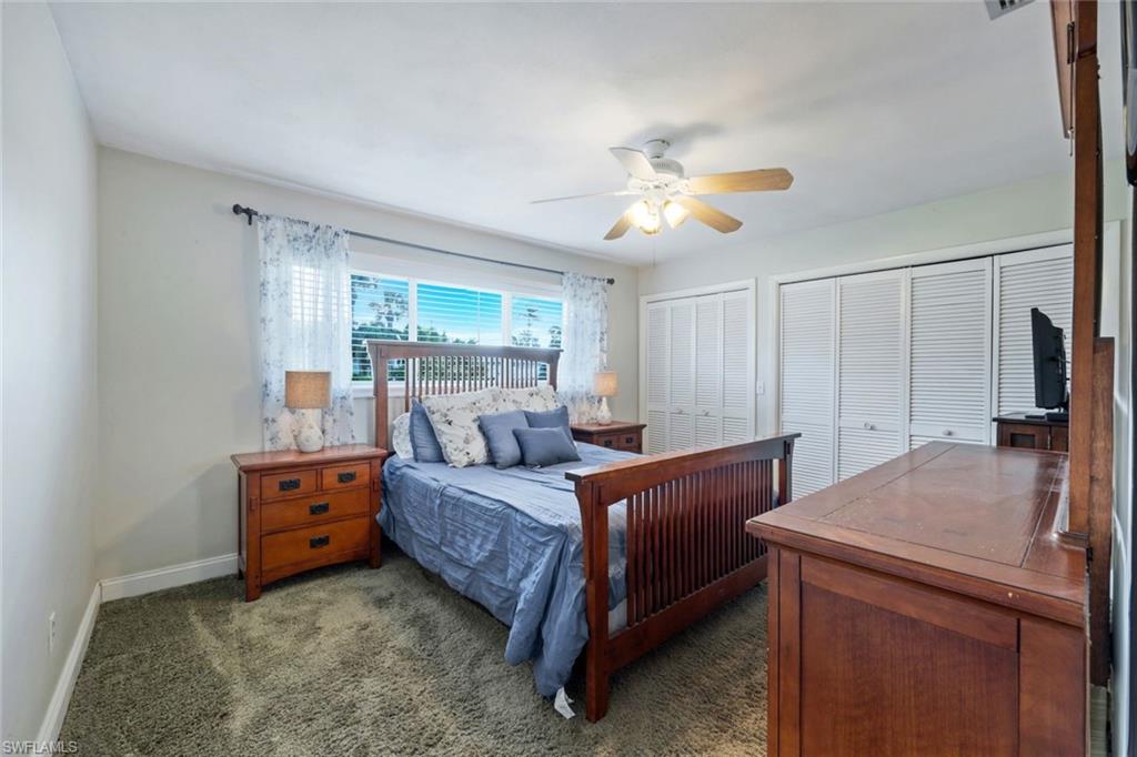 289 Burning Tree Drive Naples, FL 34105 - Photo 16 of 36 a bedroom with a bed and a chandelier