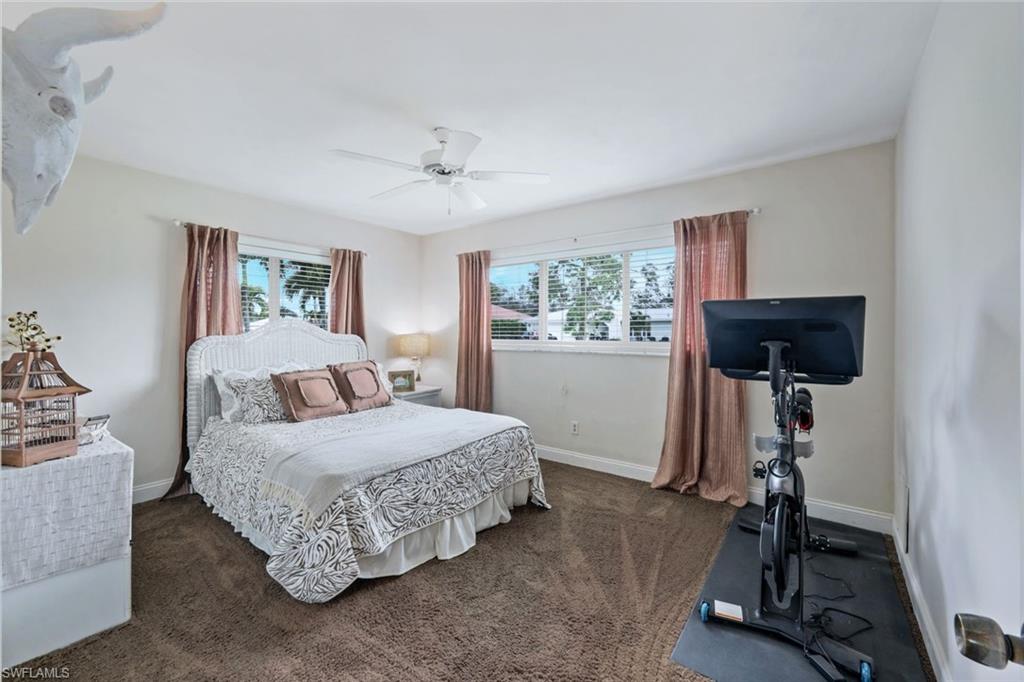 289 Burning Tree Drive Naples, FL 34105 - Photo 18 of 36 a bedroom with a bed and a window