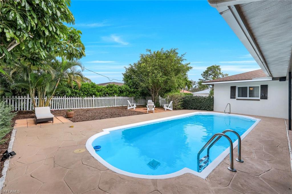 289 Burning Tree Drive Naples, FL 34105 - Photo 26 of 36 a view of a swimming pool with a patio and a yard