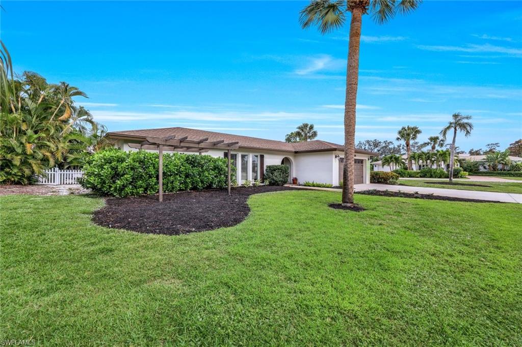 289 Burning Tree Drive Naples, FL 34105 - Photo 35 of 36 a view of a garden with a tree