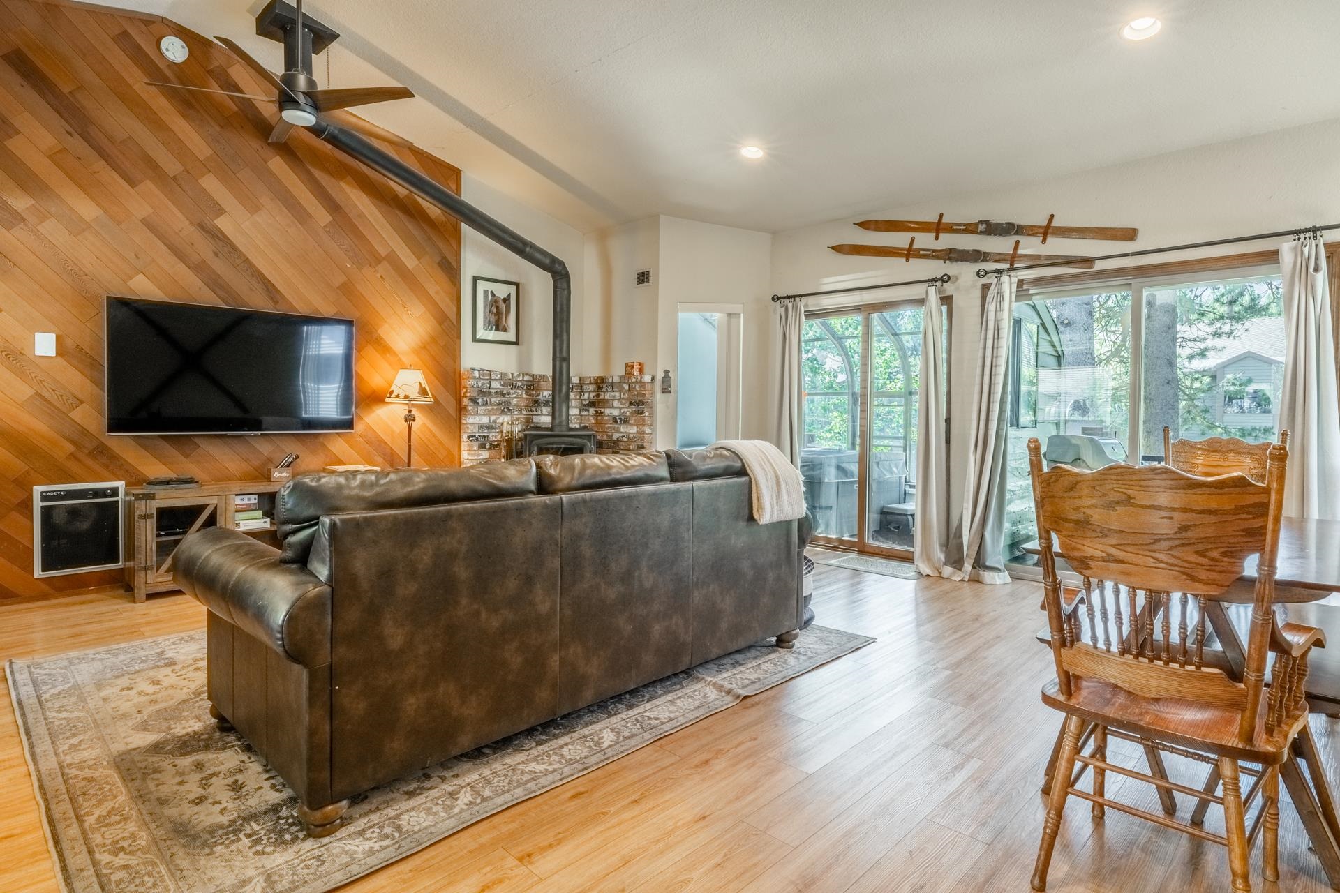 384 Joaquin Road, Unit 36 Mammoth Lakes, CA 93546 - Photo 10 of 36 Vaulted ceiling living area featuring a prominent wood accent wall, wood-finish flooring, a freestanding wood-burning stove, and recessed lighting