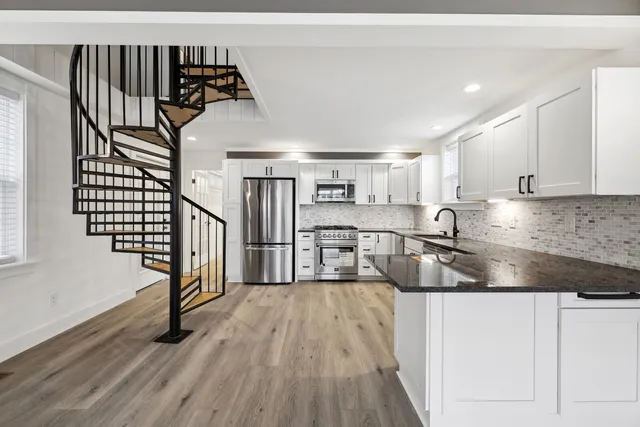a view of a kitchen with wooden floor and electronic appliances