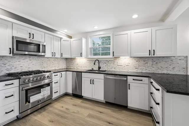a kitchen with stainless steel appliances granite countertop a sink and stove top oven