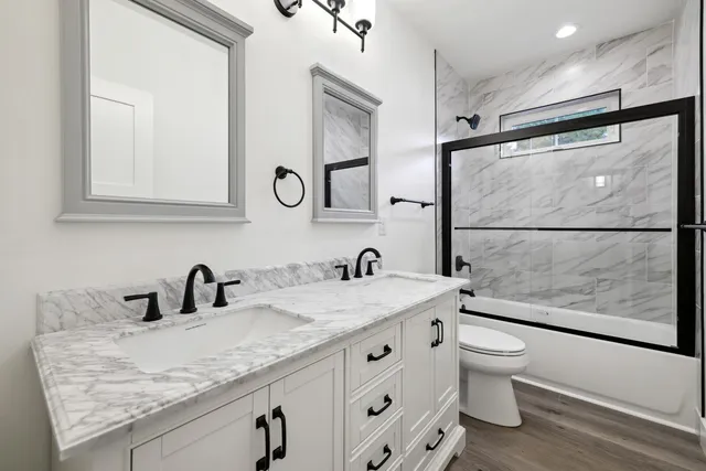 a bathroom with a granite countertop sink a toilet and mirror