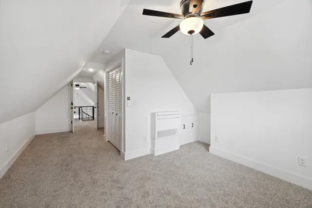 an empty room with a ceiling fan and carpet