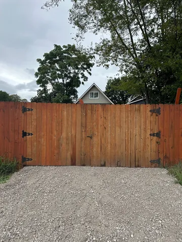 a view of wooden fence under a large tree