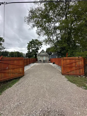 a backyard of a house with wooden fence and trees