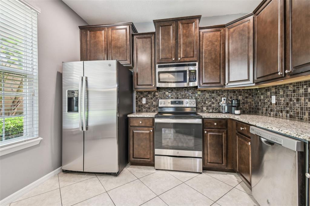 7001 Interbay Boulevard, Unit 134 Tampa, FL 33616 - Photo 11 of 84 a kitchen with granite countertop a refrigerator stove and microwave