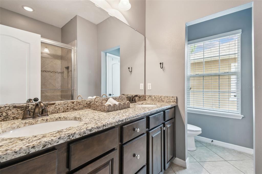 7001 Interbay Boulevard, Unit 134 Tampa, FL 33616 - Photo 34 of 84 a bathroom with a granite countertop sink a toilet and a large mirror