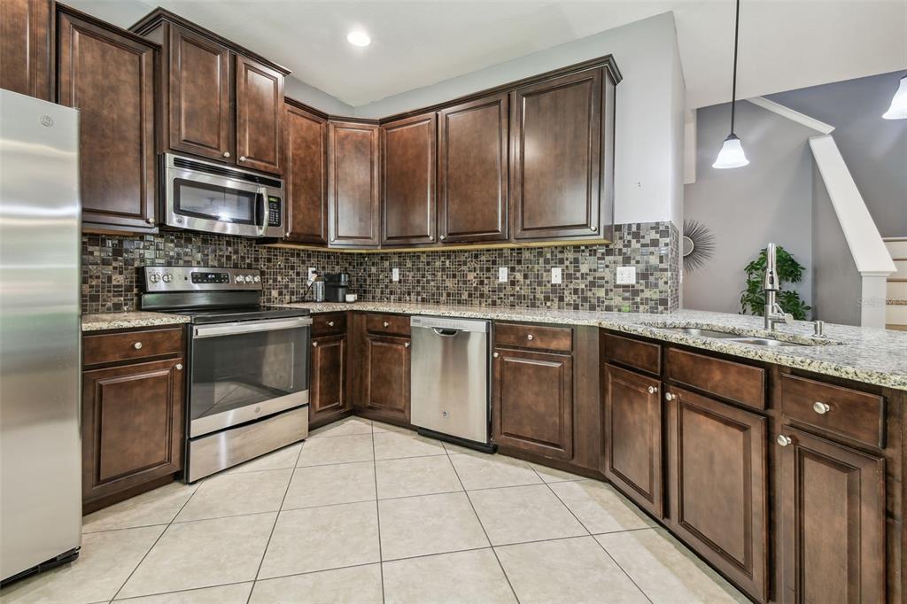 7001 Interbay Boulevard, Unit 134 Tampa, FL 33616 - Photo 10 of 84 a kitchen with stainless steel appliances granite countertop a stove microwave and cabinets
