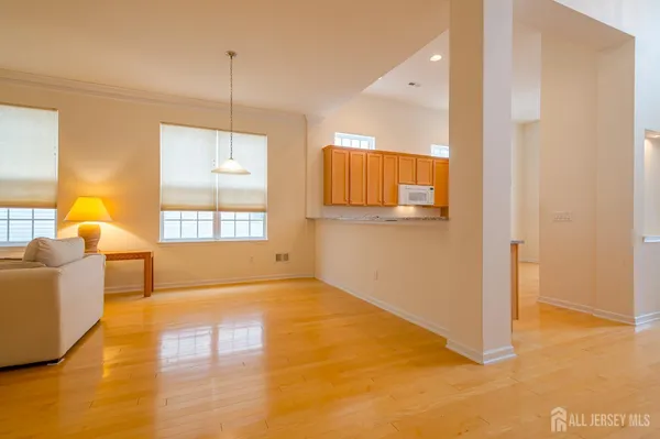 a living room with couches and kitchen view with wooden floor