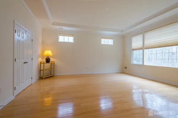 a view of an empty room with window and wooden floor