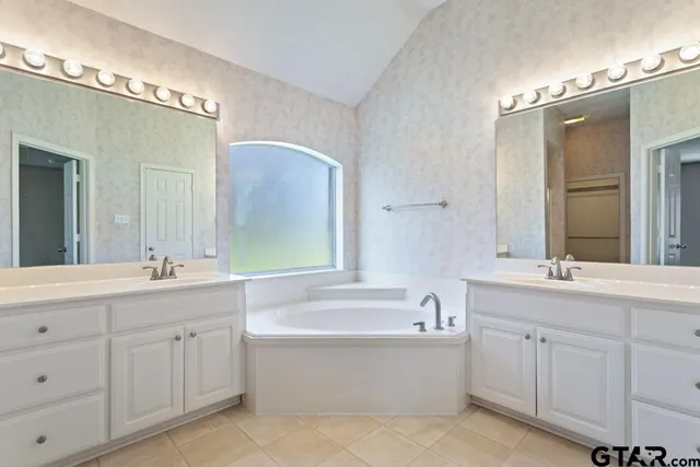 a bathroom with a double vanity sink mirror double and bathtub