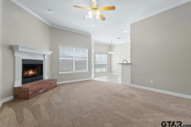 a view of an empty room with a fireplace and a window