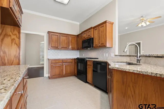 a kitchen with granite countertop a stove top oven sink and cabinets
