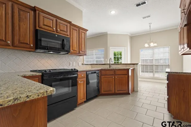 a kitchen with stainless steel appliances granite countertop a stove a sink and a microwave