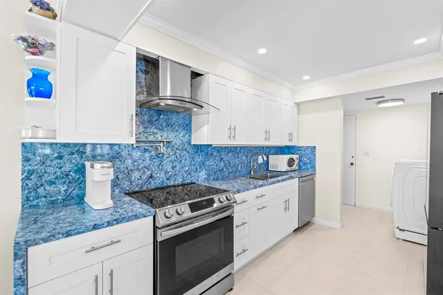 a kitchen with granite countertop a sink a stove and refrigerator