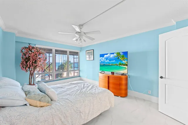 a bedroom with a bed and a large window