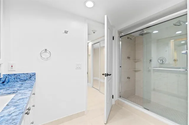 a bathroom with a granite countertop sink mirror and shower
