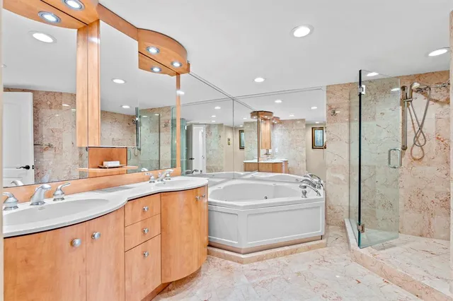 a bathroom with a tub a sink shower and mirror